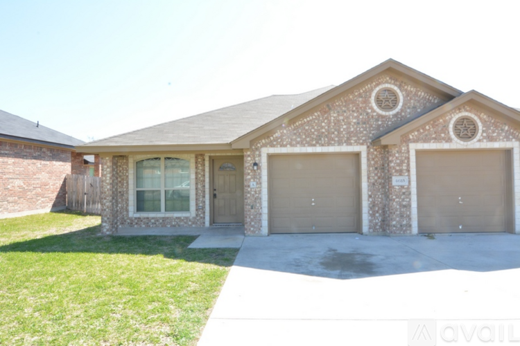 A house with a garage and a driveway in front.
