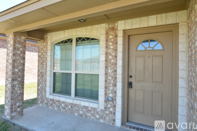 A house with a brown door and a window with white blinds.