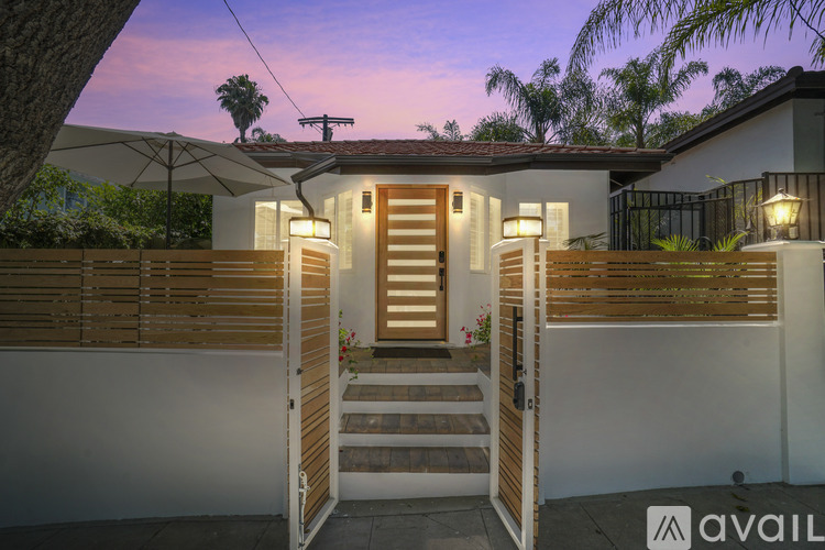 A house with a wooden fence and a staircase leading to the front door.