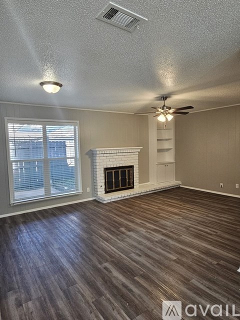 A room with a fireplace and a ceiling fan.