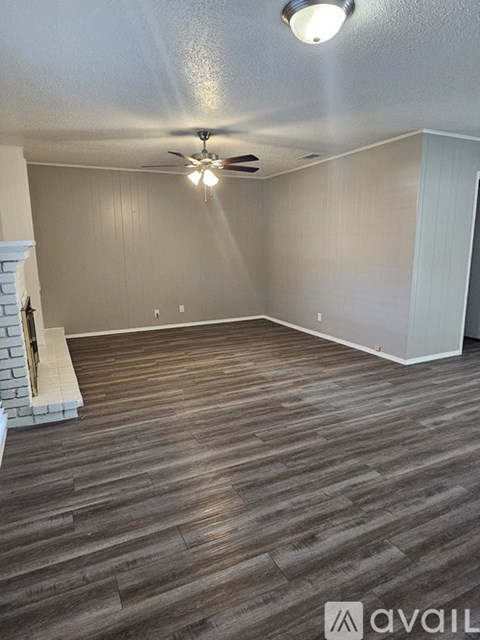 A room with a ceiling fan and wooden flooring.