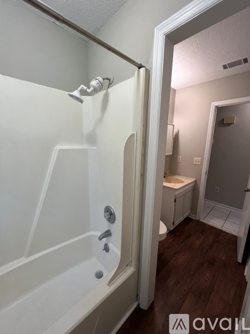 A bathroom with a white tub and a white door.