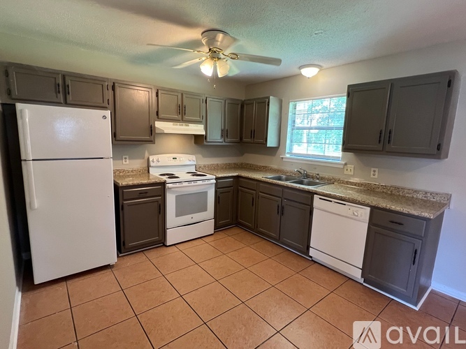 A kitchen with a white refrigerator and brown cabinets.
