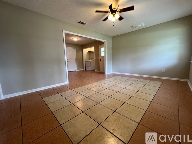 A spacious room with a ceiling fan and tile flooring.