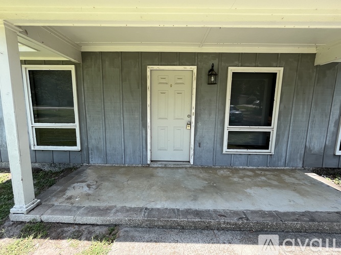 A white door is on the right side of a grey house.