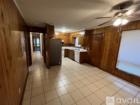 A kitchen with wooden cabinets and a white fridge.