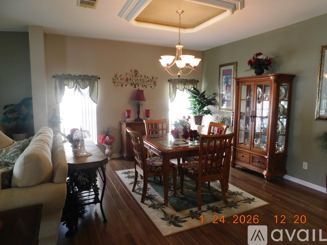 A well-lit dining room with a wooden table and chairs.