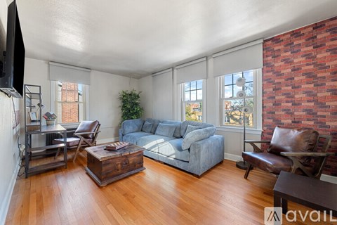 A living room with a grey couch and a wooden floor.