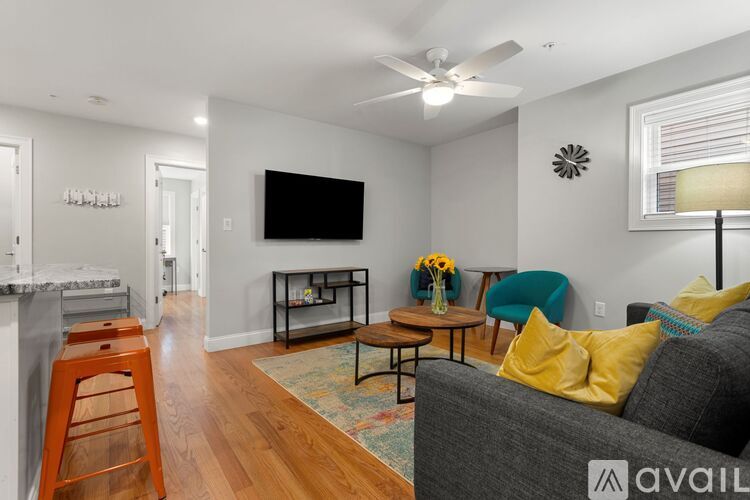 A living room with a grey couch and a black television.