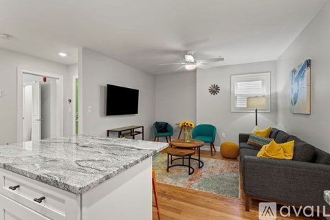 A living room with a grey couch and a marble countertop.