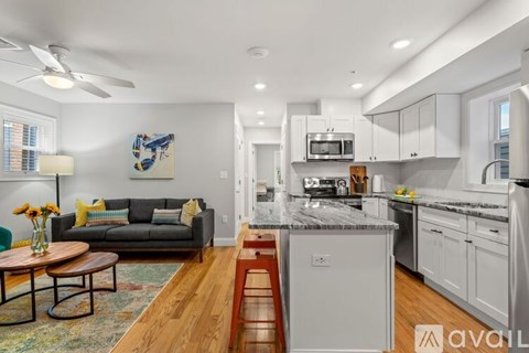 A modern kitchen with a dining table and a fan.