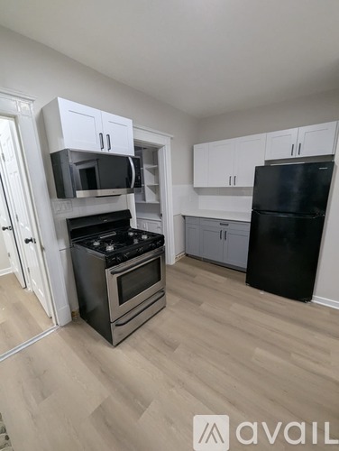 A kitchen with a black fridge, stove and microwave.