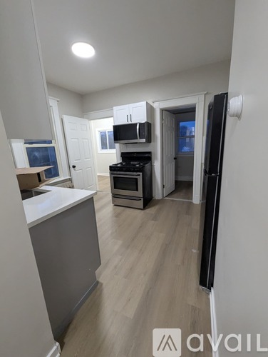 A kitchen with a white countertop and a wooden floor.
