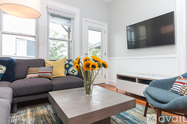 A living room with a grey couch, a brown coffee table, and a blue armchair.