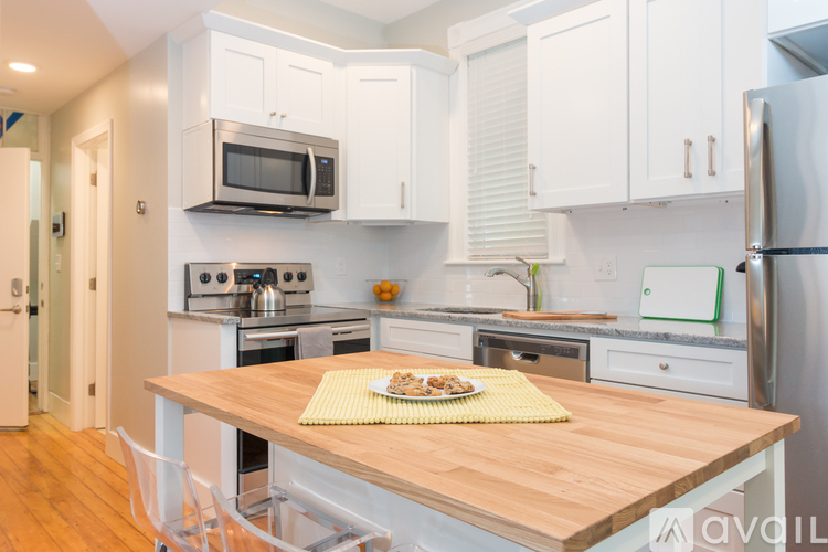A kitchen with a wooden table and white cabinets.