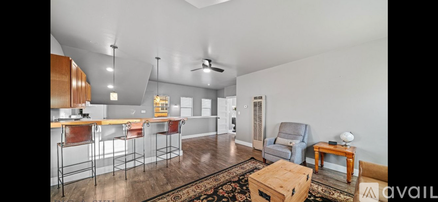 A kitchen with a bar area and a living room area.