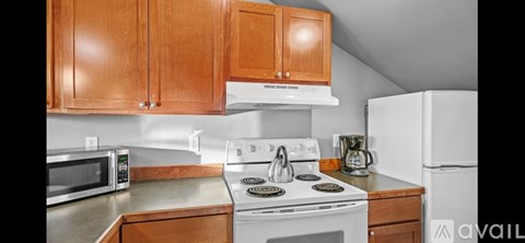 A kitchen with wooden cabinets and a white stove top.