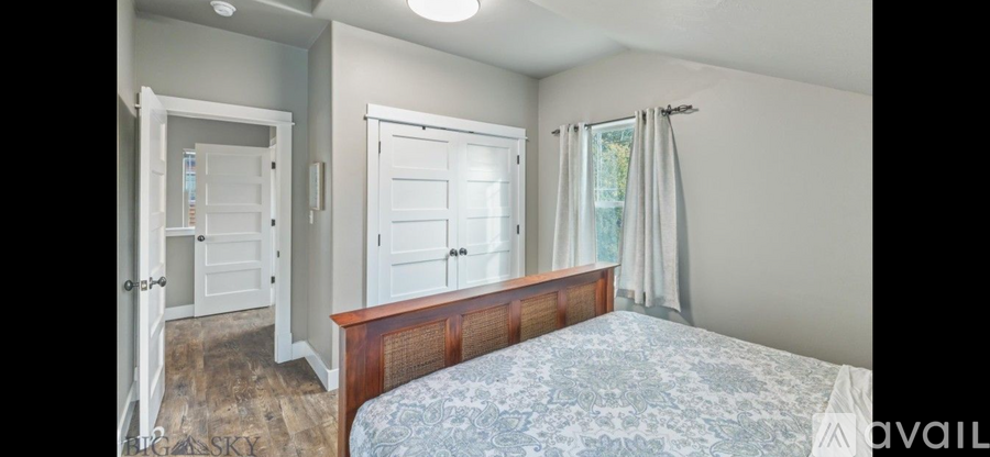 A bedroom with a bed, dresser, and mirror.