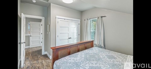A bedroom with a bed, dresser, and mirror.