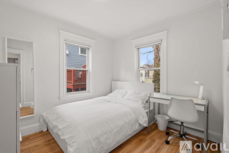 A bedroom with a bed, desk, and chair.