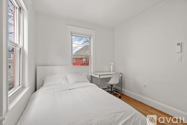 A bedroom with a bed, desk, and chair.