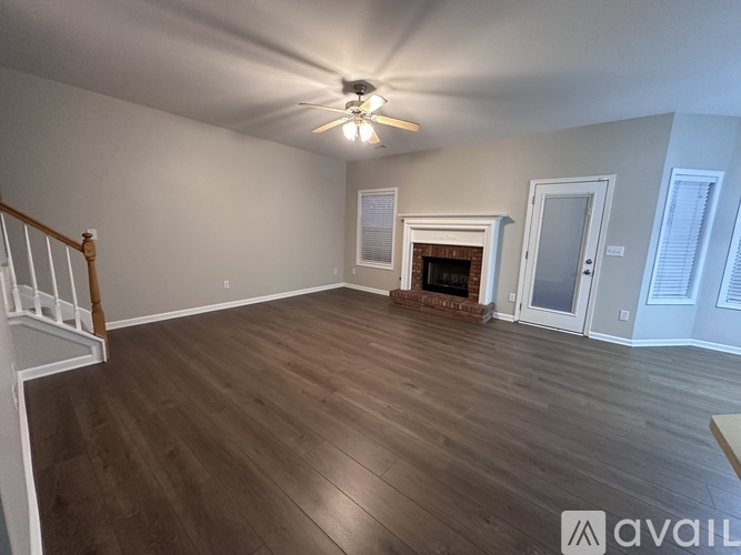 A living room with a fireplace and a ceiling fan.