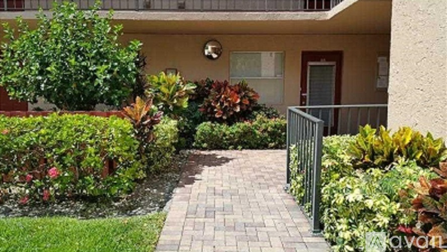 A small garden with a brick pathway leading to a building.