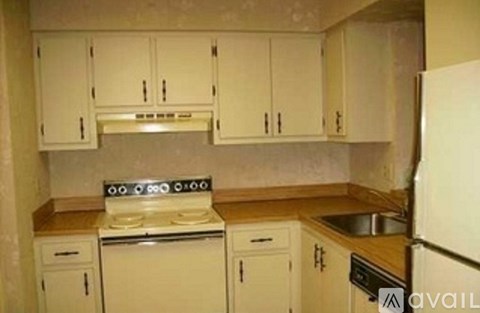 A kitchen with white cabinets and appliances.
