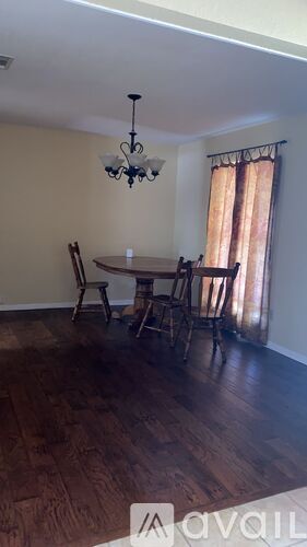 A dining room with a table and chairs.