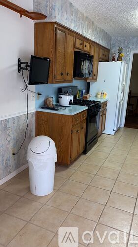 A kitchen with wooden cabinets and a white refrigerator.