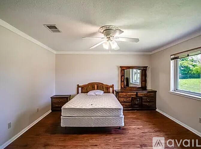 A bedroom with a bed, dresser, and mirror.
