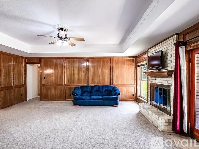 A living room with a blue couch and a fireplace.