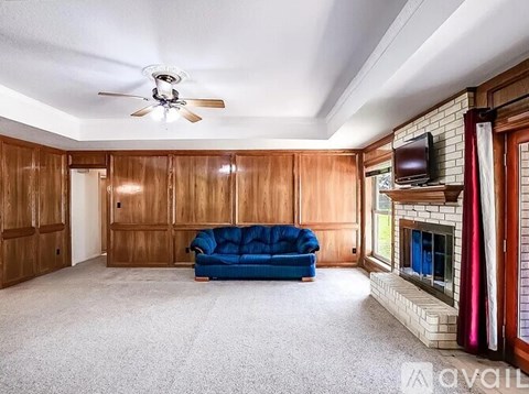 A living room with a blue couch and a fireplace.