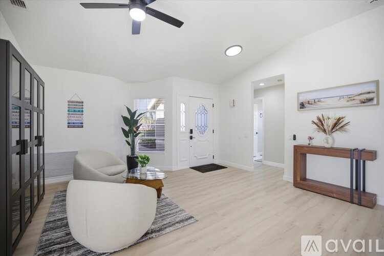A living room with a white chair and a wooden coffee table.