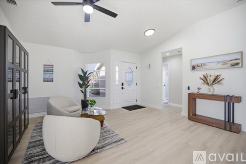 A living room with a white chair and a wooden coffee table.