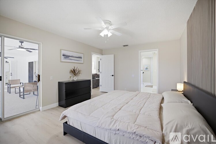 A bedroom with a large bed and a ceiling fan.