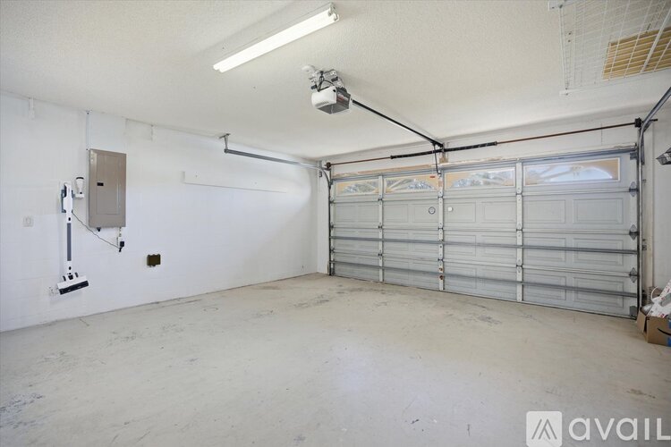 A spacious garage with a closed shutter door and a white wall.