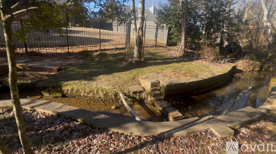 A small waterfall in a garden surrounded by trees.