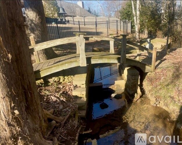 A wooden bridge over a small stream in a wooded area.