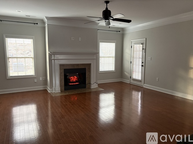 A living room with a fireplace and a ceiling fan.