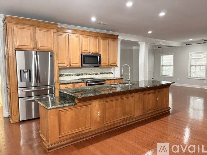 A kitchen with wooden cabinets and a granite countertop.
