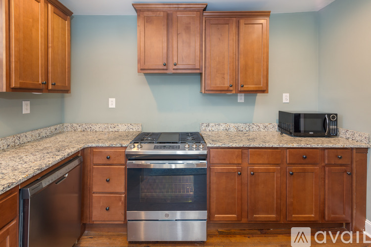 A kitchen with wooden cabinets and a granite countertop.