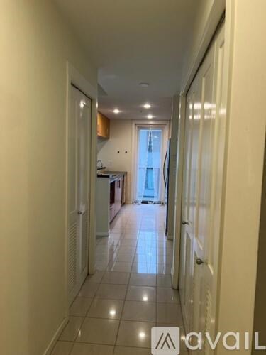 A long hallway with a kitchen visible in the distance.
