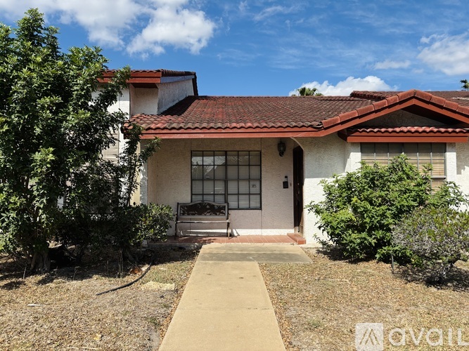 A house with a red tile roof and a white wall with a window and a door.