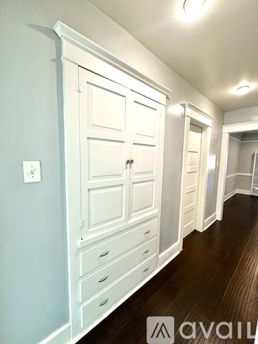 A room with a ceiling fan and wooden flooring.