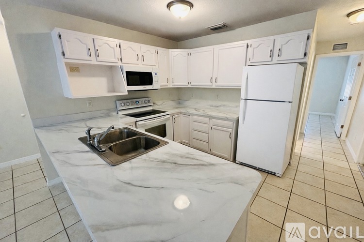 A kitchen with white appliances and cabinets.