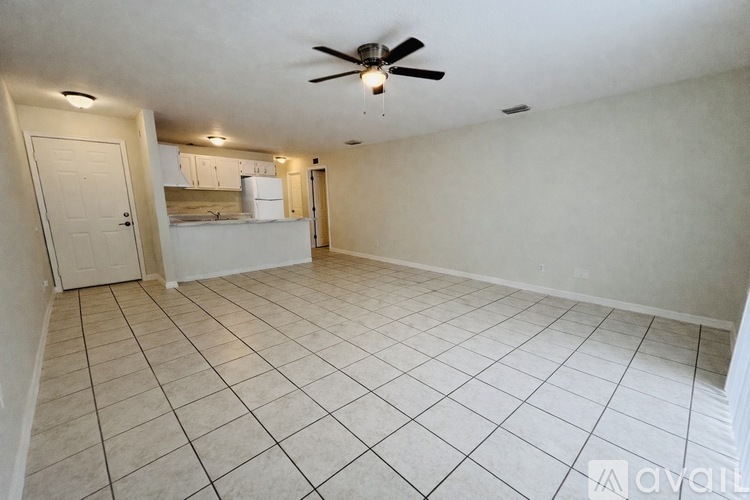 A room with a ceiling fan and tile flooring.