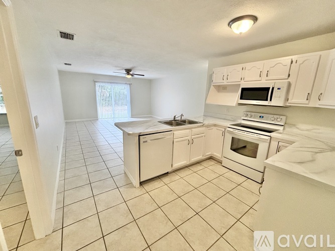 A kitchen with white cabinets and appliances.