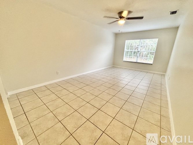 Empty room with a ceiling fan and a window with blinds.