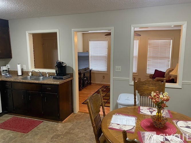 A kitchen with a dining table set for two.